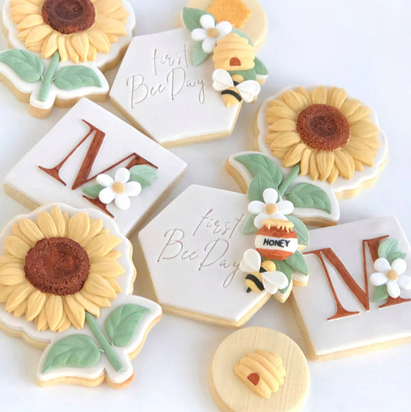 Decorative cookies with sunflowers, bees, and honeycomb on a white background