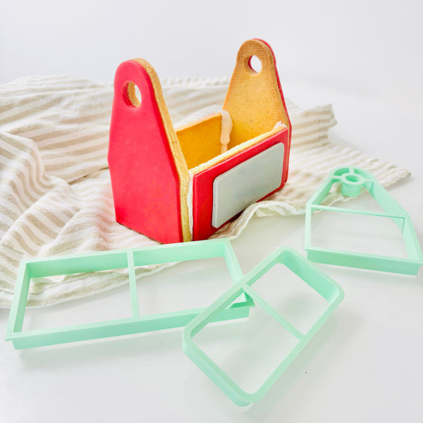 Red and yellow rectangular objects with cut-out designs on a textured white surface